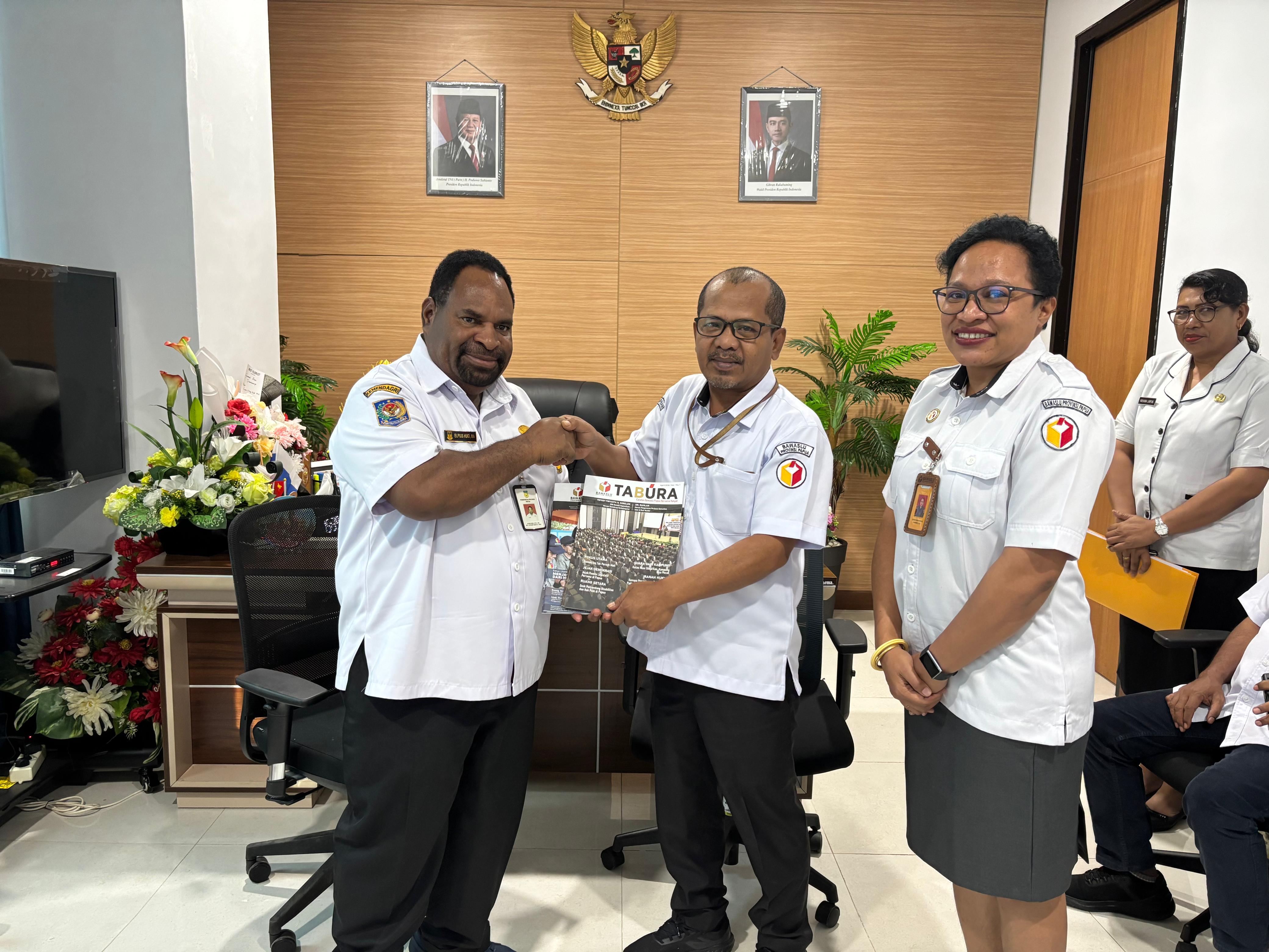 Hardin Halidin Ketua Bawaslu Papua bersama Yofrey Piryamta Anggota saat beri buletin Tabura ke Kepala Kesbangpol Provinsi Papua | Foto diambil oleh Barnas